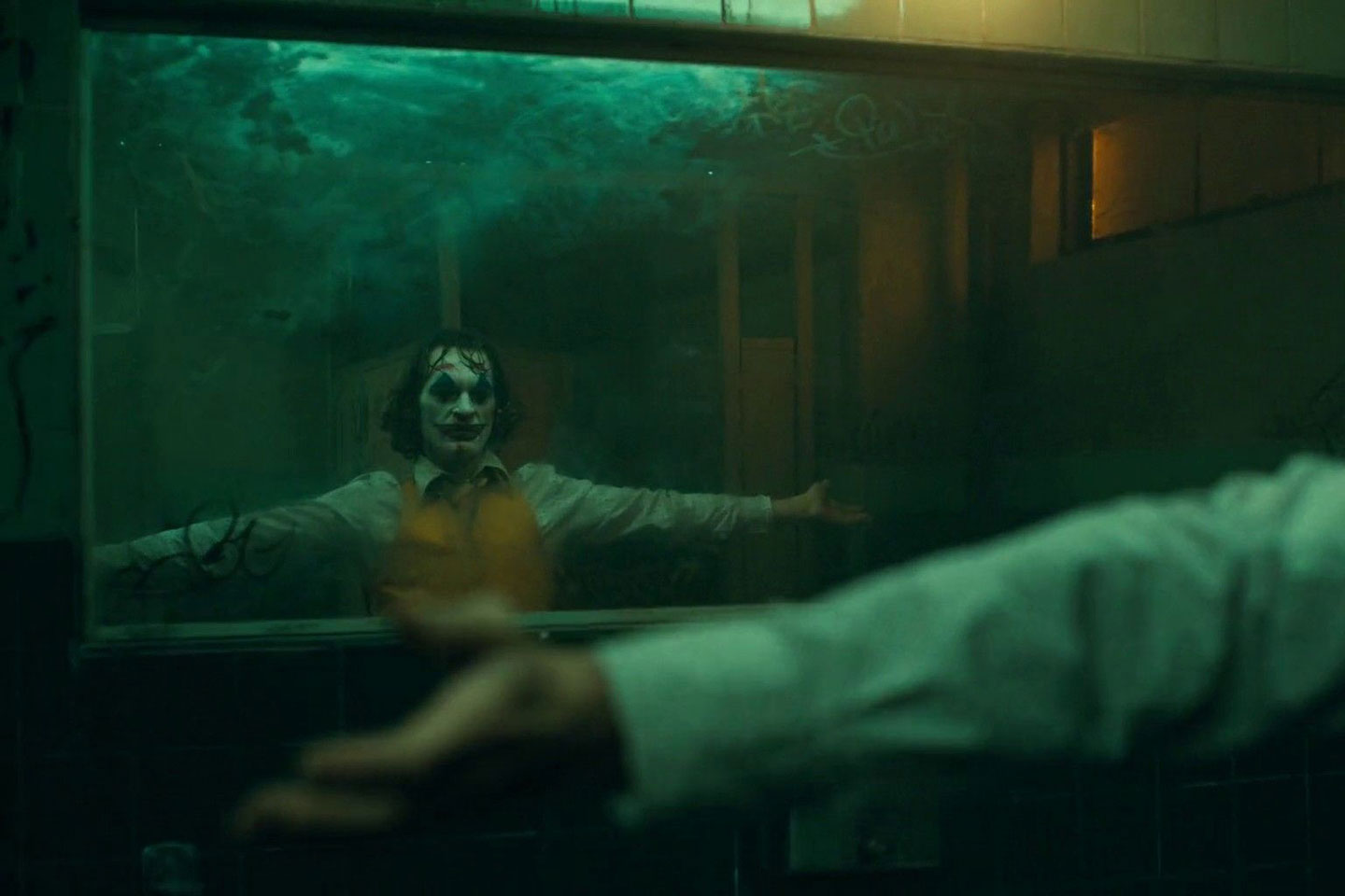 Joaquin Phoenix looks in mirror in the bathroom dance scene of Todd Phillips’ 2019 film Joker